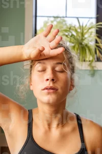 woman touching her head in pain eyes shut